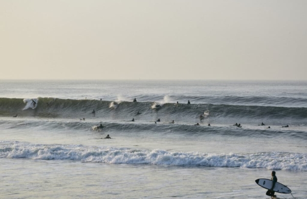 Surfeurs profitant des vagues à Rockaway Beach, une destination prisée pour les amateurs de surf