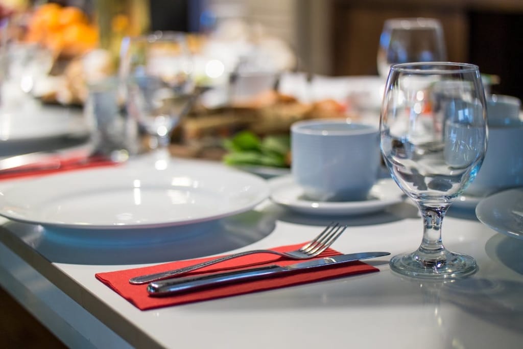 Table d'un restaurant dressée avec assiette, couverts, verre, tasse de café