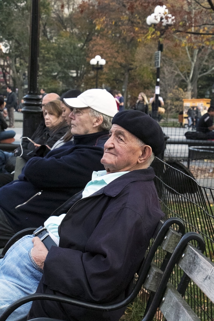 Homme agé assis sur un. banc du Washnigton Square Park