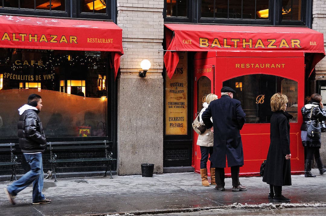 Devanture rouge du restaurant Balthazar à New York avec des personnes qui attendent devant