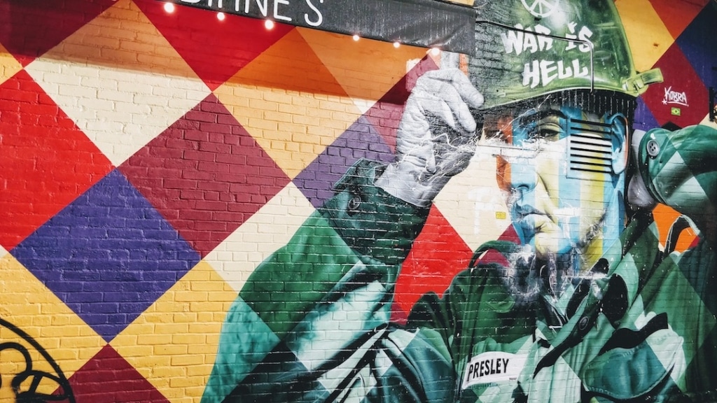 Œuvre de street art colorée représentant Elvis Presley en soldat